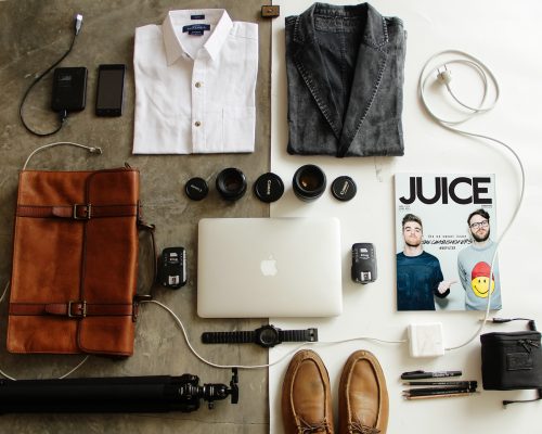 organizing your stuff: leather bag, macbook, watch, shirts, shoes, a magazine, photography accessories, cords, pencils, and a pen