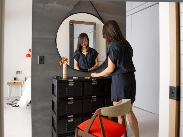 a woman standing in front of locker-inspired storage cubes and organizing things