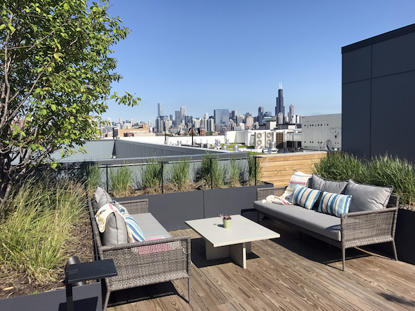 brianne bishop's luxe on chicago rooftop project scene 2: a coffee table in the middle of two outdoor benches facing eachother