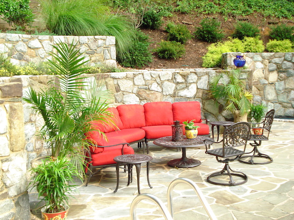 june shea backyard seating with red cushions, 2 side tables, a coffee table, and 2 outdoor chairs