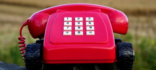 how to switch utilities and services when moving: red vintage phone on wheels