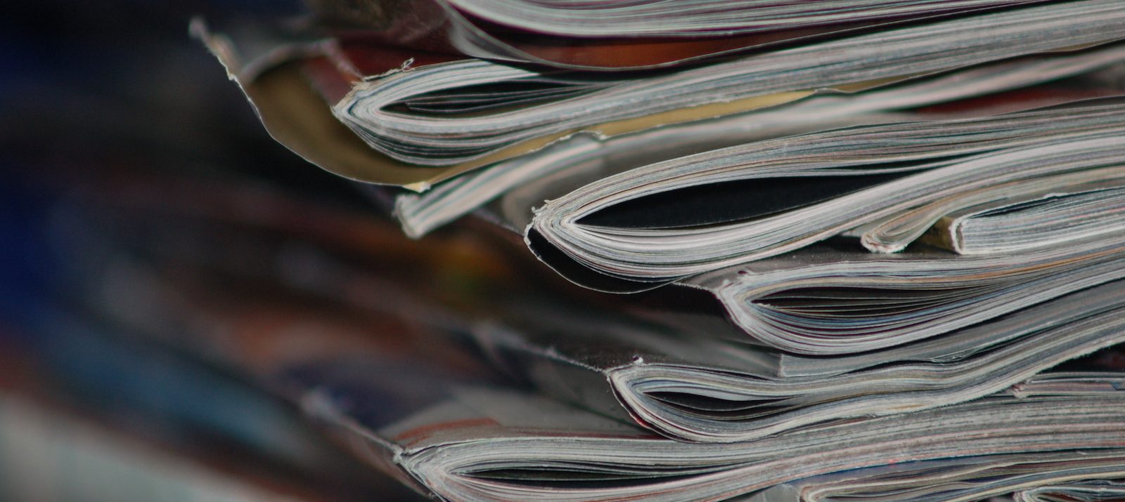 A stack of old magazines on a desk.