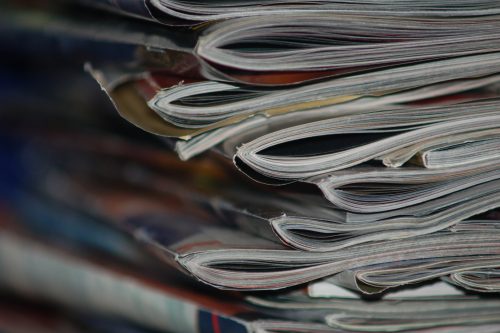 A stack of old magazines on a desk.