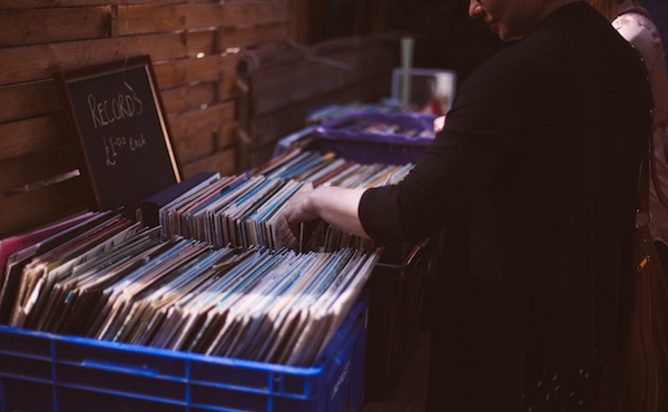 Someone rifles through a collection of old LP vinyls