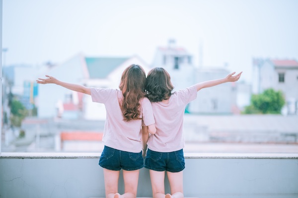 Two girls are celebrating with their hands in the air