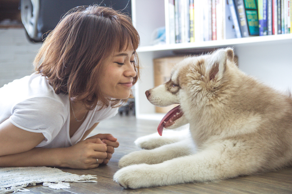 a woman smiles at her really cute dog