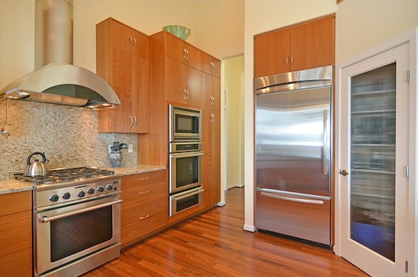 a kitchen with hardwood floors and steel appliances