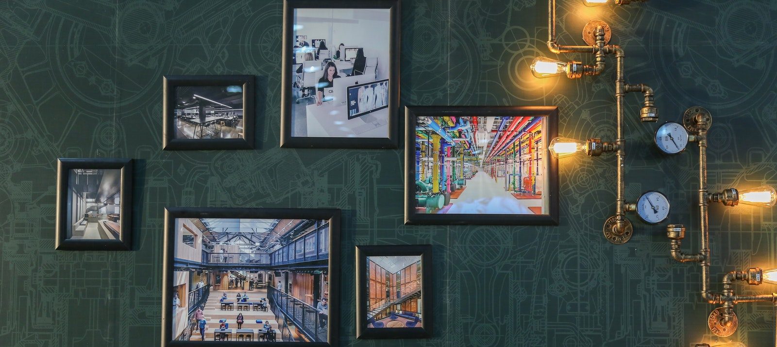 picture frames on a patterned wall being lit by lightbulbs