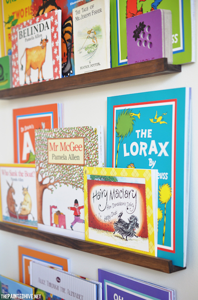 three behind-the-door bookshelves holding children's books