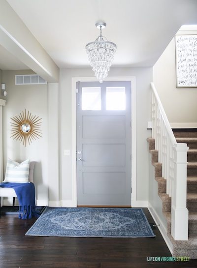 the entryway to a home with a hanging chandelier