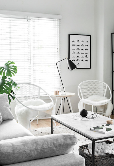a peaceful white living room with two chairs and a sofa