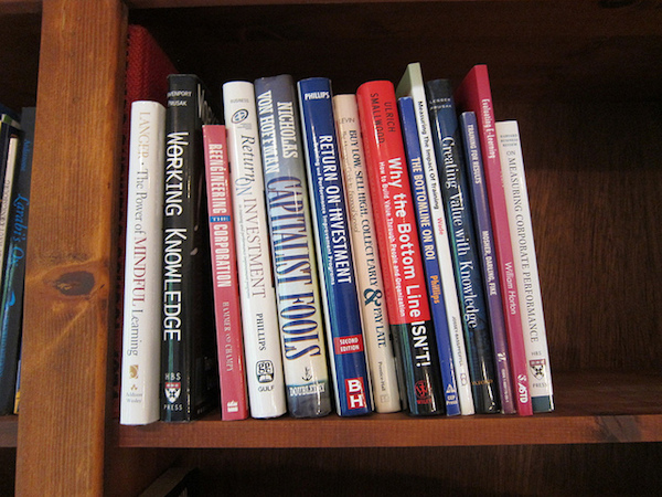 A small collection of books are lined up on a shelf