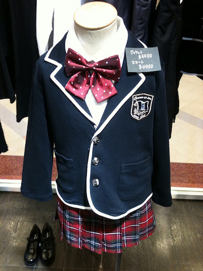 A child's school uniform complete with a satin bow and shoes