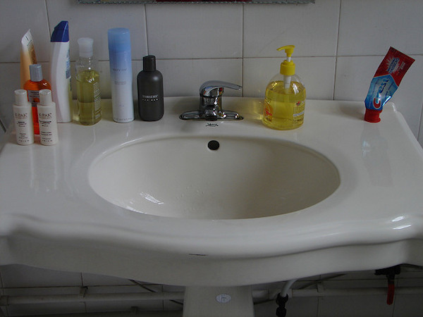 a white bathroom sink hosts a number of toiletries