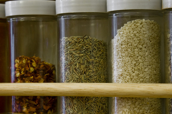 A closeup of 3 spices in 3 separate plastic spice bottles