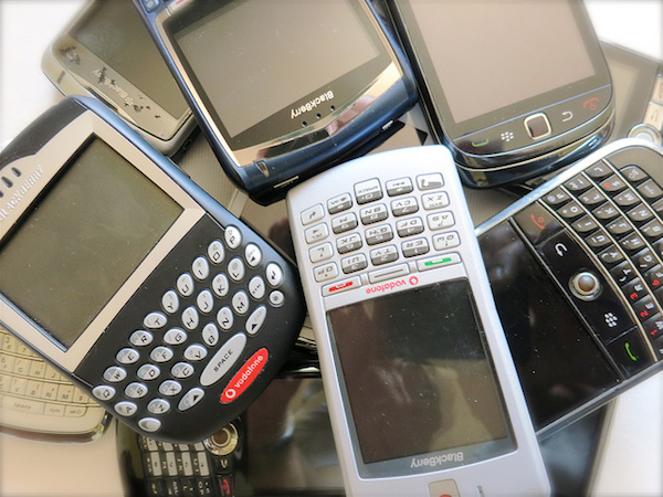 A pile of old phones like Blackberry and Vodaphone