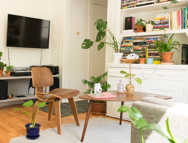 a wooden chair and small desk are a makeshift home office inside a living room