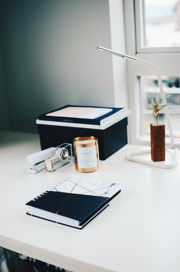 a desk with a printer and small reading lamp