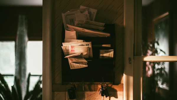 a pile of papers and mail cluttered together in a wall mail organizer