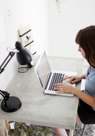 a woman doing work on her computer at her desk inside a home