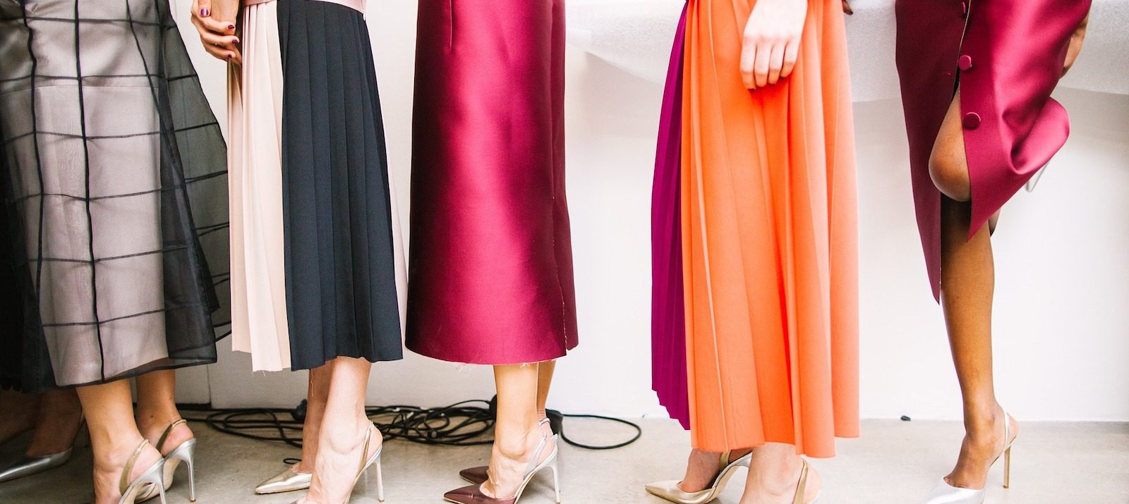5 women wearing different skirts and dresses