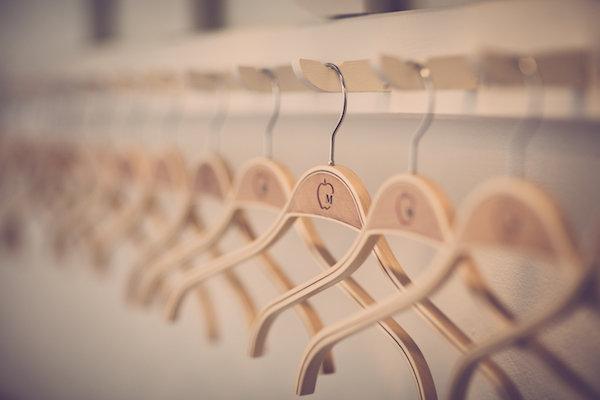 wooden hangers hanging on a wall-mounted board with hooks