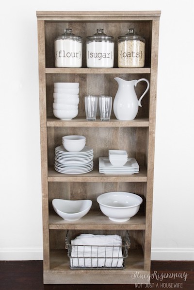 a large brown bookcase has been converted into a storage space for dishes