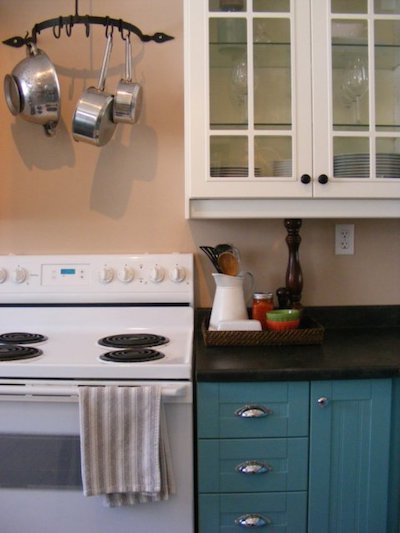 a hanging pot rack over a white kitchen stovetop