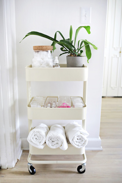 ikea raskog utility cart storing toiletries, a houseplant, towels, and more