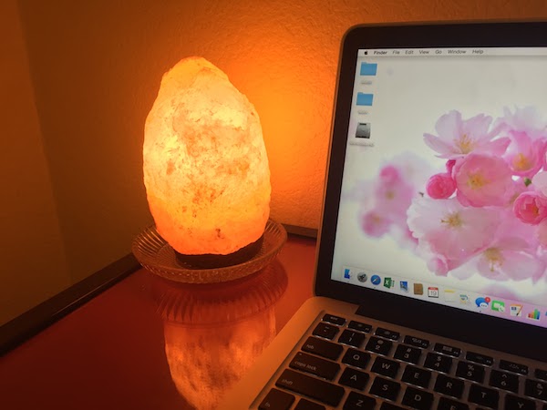 himalayan salt lamp next to a macbook on a table