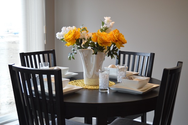 fresh white and yellow flowers in a white vase on a kitchen table