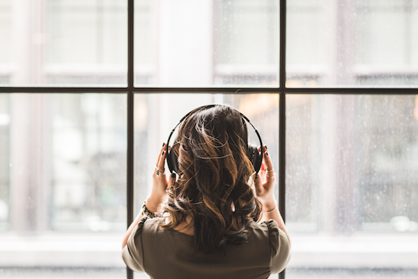 a woman wearing headphones looking out the window