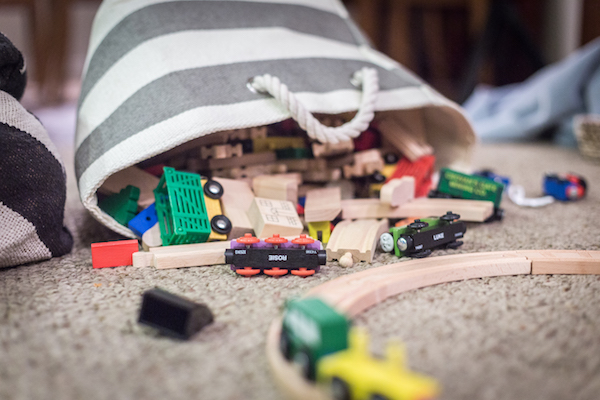 toys spill out of a canvas bag in a play space