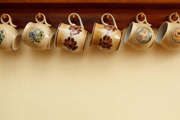 teacups hanging from under cabinet on hooks