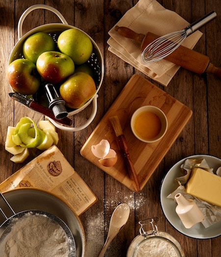 a wooden table with provisions for preparing a meal