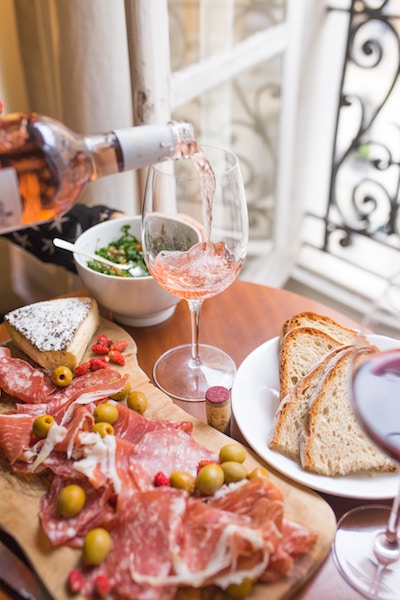 rose being poured alongside a charcuterie platter