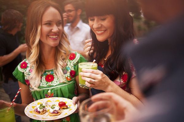 two women enjoy a dinner party in the backyard