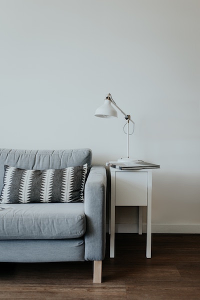 a nightstand and a couch in a white room