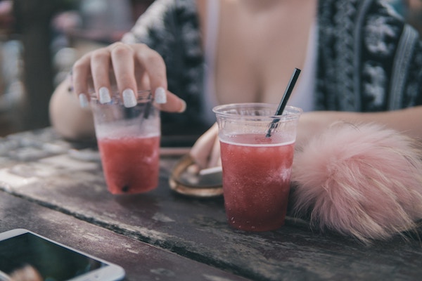 a closeup of a woman's hand holding a beverage while out at a bar 