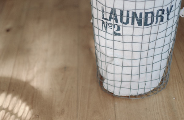 a laundry bag waits on the floor of a room