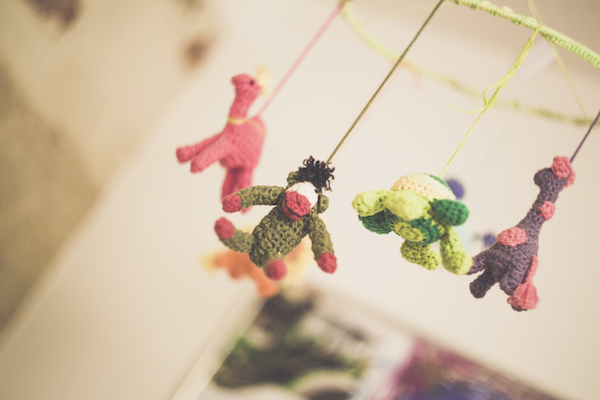a mobile of friendly knit stuffed animals