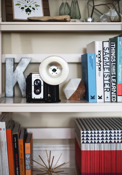 a bookshelf with some knickknacks and small art displayed