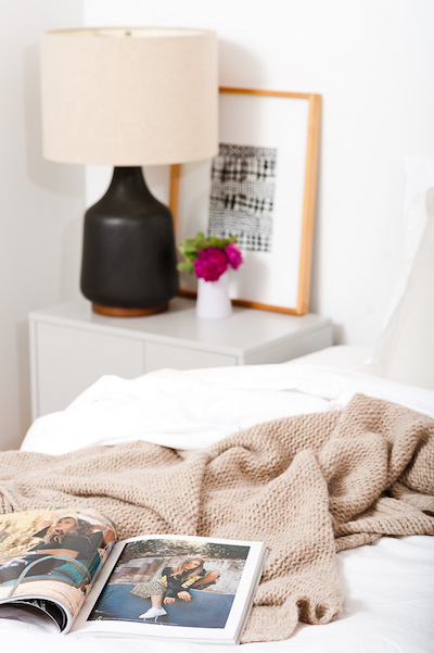 a piece of art is propped up against the wall next to a bed