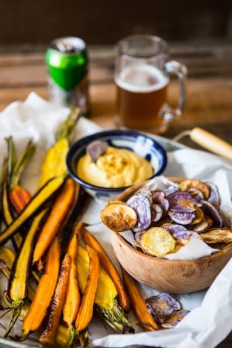 a table with snacks like dried veggies and beer