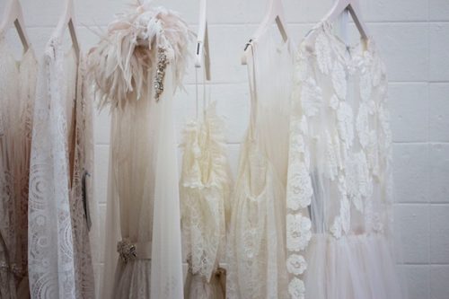 a row of wedding dress on a clothing rack