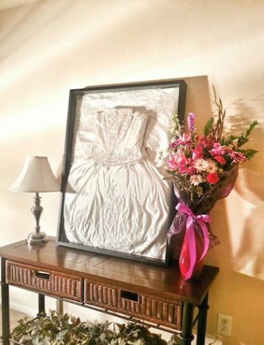 a framed wedding dress on an entryway table