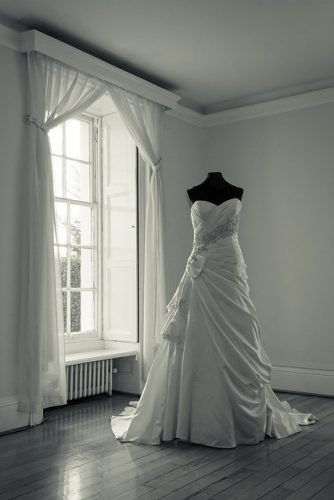 a wedding dress on a mannequin in an otherwise empty room