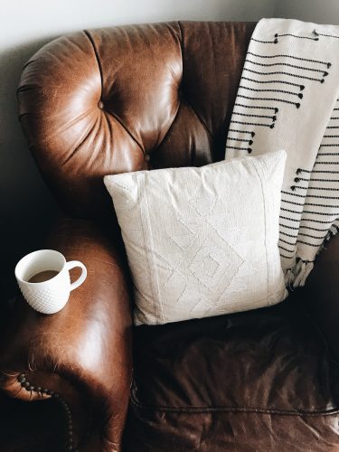 a comfy leather couch with a blanket