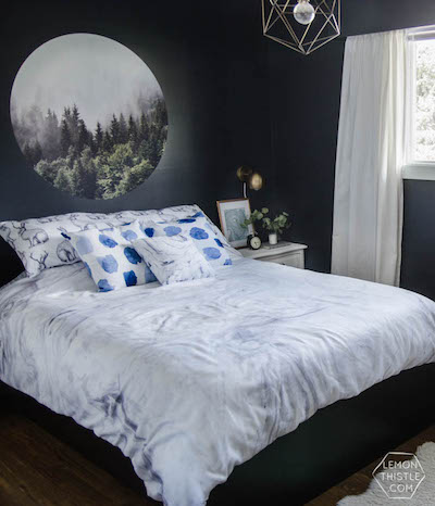 bed against dark wall with mural