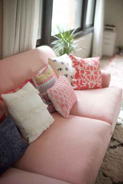 assorted throw pillows on pink sofa